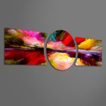 An abstract painterly skyscape of vivid red, pink, yellow and purple clouds sweeping over a glowing horizon and its reflection. 3 piece glass wall art set F