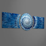 An abstract 3D starburst of blue and silver shards radiating outward from a bright glowing white center. 3 piece glass wall art set F