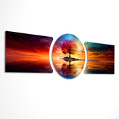 A vivid multicolored tree standing on a small island, perfectly mirrored in calm water beneath a blazing sunset sky. 3 piece glass wall art set D