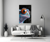Close-up detail of turquoise gecko with marigold eye behind glass