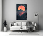 Close-up detail of red-orange moon over peaks behind glass