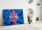 Close-up detail of Pistons logo on cobalt banner behind glass