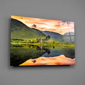Scottish loch ruin sunset glass wall art over walnut console with single-malt decanter