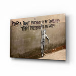 Banksy people-pretend cinematic glass wall art over walnut console in designer office