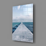 Close-up detail of concrete pier extending toward the cloud-streaked horizon