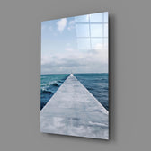 Close-up detail of concrete pier extending toward the cloud-streaked horizon