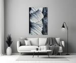Abstract glass wall art styled above a coffee table in a living room