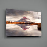 Mountain close-up showing rust-red volcanic peak mirrored on still water