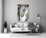 Abstract glass wall art styled above a credenza in a living room