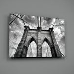 Brooklyn Bridge close-up showing Gothic arches and suspension cables under cloudy sky