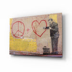 Graffiti Doctor glass wall art displayed above a tan leather sofa in a goldenrod-painted lounge with reclaimed-wood coffee table and brass picture light