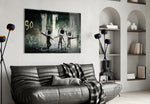 TV Heads glass wall art styled above a sofa in a gaming room