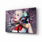 Harley Quinn glass wall art displayed above a black gaming sofa in a brick-walled lounge with neon arcade sign and reclaimed-wood console