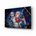 Harley Quinn and the Joker glass wall art displayed above a black gaming sofa in a brick-walled lounge with neon arcade sign and matte-black coffee table