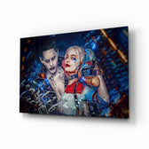 Harley Quinn and the Joker glass wall art displayed above a black gaming sofa in a brick-walled lounge with neon arcade sign and matte-black coffee table
