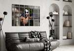 Joker glass wall art styled above a sofa in a gaming room