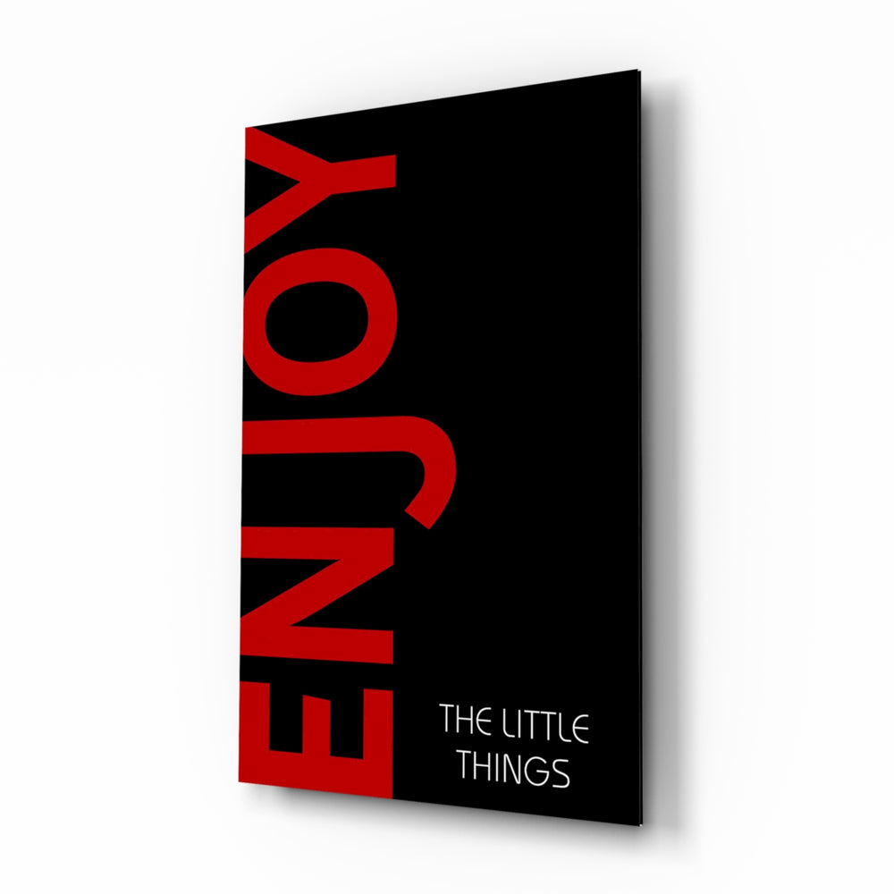 Enjoy The Little Things glass wall art displayed beside a charcoal sofa in a slate-walled office with steel desk and matte-black shelving