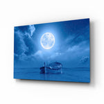 Moon and Boat glass wall art displayed above a linen bed in an azure bedroom with brushed-brass sconces and rattan nightstands