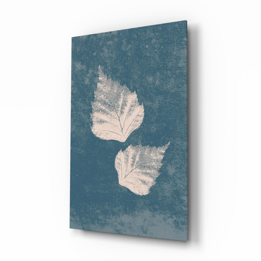 Falling Leaves glass wall art displayed above a marble vanity in a slate-blue bathroom with brushed-brass faucet and stoneware tray