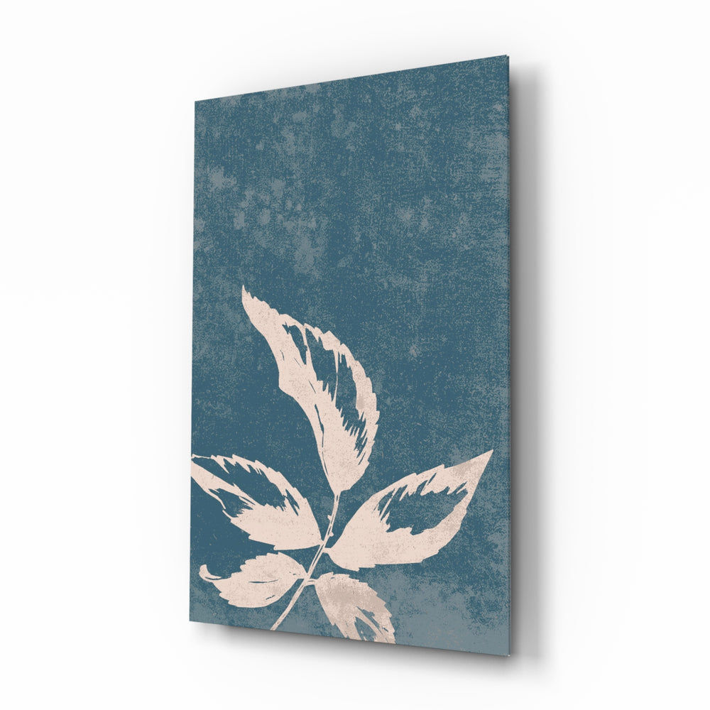 Leaves glass wall art displayed above a marble vanity in a slate-blue bathroom with brushed-brass faucet and stoneware tray