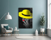 Yellow Hat glass wall art styled above a bed in a bedroom