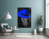 Blue Hat glass wall art styled above a bed in a bedroom
