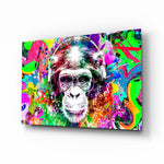 Monkey Face glass wall art displayed above a black gaming sofa in a brick-walled lounge with neon arcade sign and matte-black coffee table