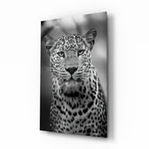 Leopard glass wall art displayed beside a leather chesterfield in a slate-walled man cave with reclaimed-wood console and matte-black floor lamp