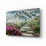 Footpath to Mountains glass wall art displayed above a linen sofa in a sage living room with rattan armchair and woven floor rug