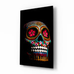 Sugar Skull glass wall art displayed above a black leather sofa in a moody lounge with reclaimed-wood console and brass picture light