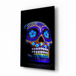 Sugar Skull glass wall art displayed above a black leather sofa in a moody lounge with reclaimed-wood console and brass picture light