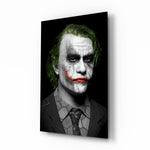 Joker glass wall art displayed above a black leather sofa in a moody home theater with brass arc lamp and reclaimed-wood console