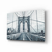 Brooklyn Bridge glass wall art displayed above a linen sofa in a slate living room with walnut console and brass picture light