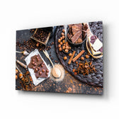 Chocolate glass wall art displayed above a walnut counter in a contemporary kitchen with rattan pendants and matte-black cabinets