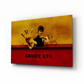 Bruce Lee glass wall art displayed above a leather chesterfield in a moody man cave with reclaimed-wood console and brass arc lamp