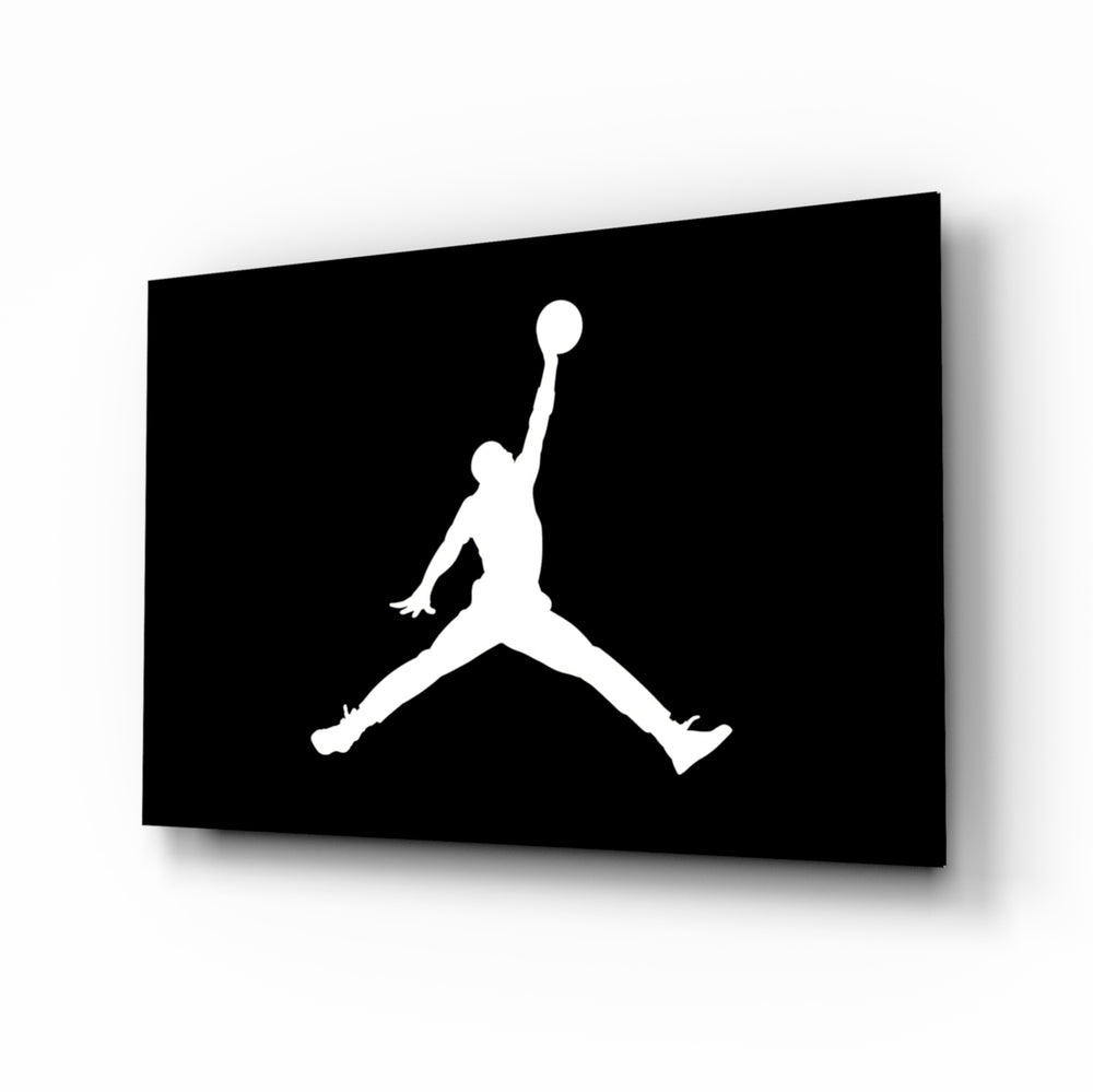 Air Jordan glass wall art displayed above a leather chesterfield in a moody man cave with reclaimed-wood console and brass arc lamp