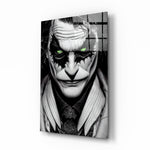 Joker glass wall art displayed above a black leather sectional in a moody home theater with blackout drapes