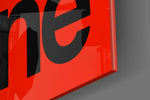 Typographic artwork anchoring a desk wall with black-on-crimson palette