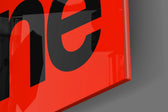 Typographic artwork anchoring a desk wall with black-on-crimson palette