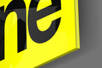 Typographic artwork anchoring a desk wall with black-on-lemon palette