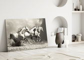 Close-up detail of three white horses thundering through golden dust