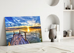 Close-up detail of weathered dock pointing toward a vivid sunset