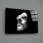 Close-up detail of Léon in round sunglasses behind glass