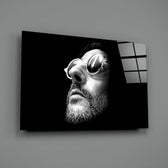 Close-up detail of Léon in round sunglasses behind glass