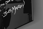 Words of Bob Marley glass wall art catching light to reveal its painted lettering