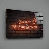 Close-up detail of tangerine neon music quote behind glass