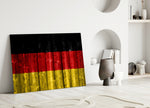 Close-up detail of weathered-wood German flag behind glass