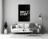 Close-up detail of Don't Quit Do It typography behind glass
