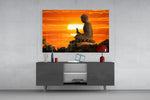 Buddha glass wall art catching light to reveal its painted sunset