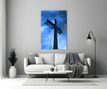 Close-up detail of stone cross in cobalt rain behind glass